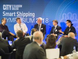 City of Glasgow College Smart Shipping Symposium panel sitting on stage with a Smart Shipping Symposium blue background. 